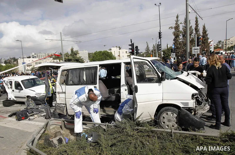 Israeli police and rescue workers inspect the car a Palestinian man used to deliberately rammed it into a crowd of pedestrians in Jerusalem on November 5, 2014. One person was killed and at least nine others wounded. Pol...