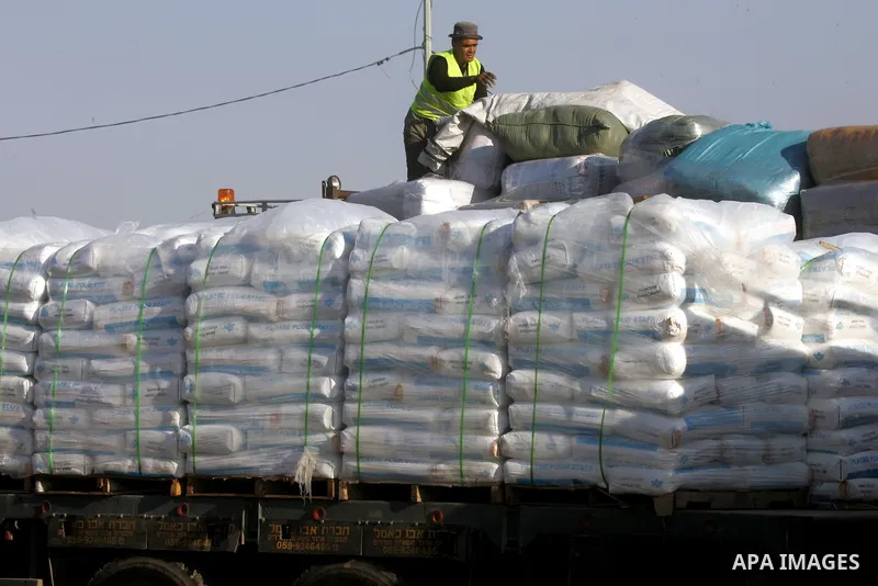 A Palestinian worker removes the plastic cover on a top of a truck loaded with supplies that entered the Gaza Strip from Israel through the Kerem Shalom crossing in Rafah in the southern Gaza Strip on November 5, 2014. U...