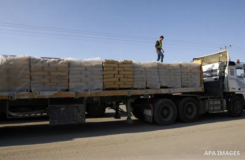 A Palestinian worker walks on top of bags of cement loaded on a truck that entered the Gaza Strip from Israel through the Kerem Shalom crossing in Rafah in the southern Gaza Strip on November 5, 2014. UN peace envoy Robe...