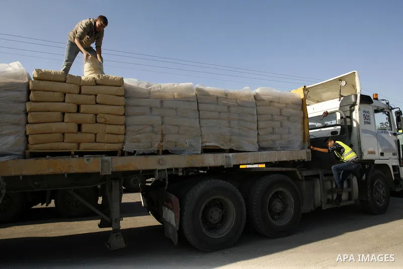 A Palestinian worker adjusts bags of cement loaded on a truck that entered the Gaza Strip from Israel through the Kerem Shalom crossing in Rafah in the southern Gaza Strip on November 5, 2014. UN peace envoy Robert Serry...