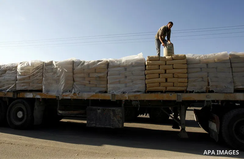 A Palestinian worker adjusts bags of cement loaded on a truck that entered the Gaza Strip from Israel through the Kerem Shalom crossing in Rafah in the southern Gaza Strip on November 5, 2014. UN peace envoy Robert Serry...