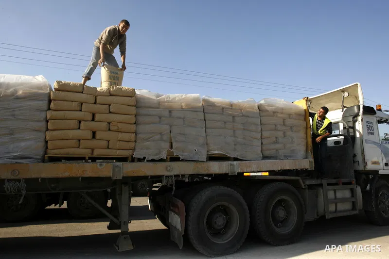 A Palestinian worker adjusts bags of cement loaded on a truck that entered the Gaza Strip from Israel through the Kerem Shalom crossing in Rafah in the southern Gaza Strip on November 5, 2014. UN peace envoy Robert Serry...