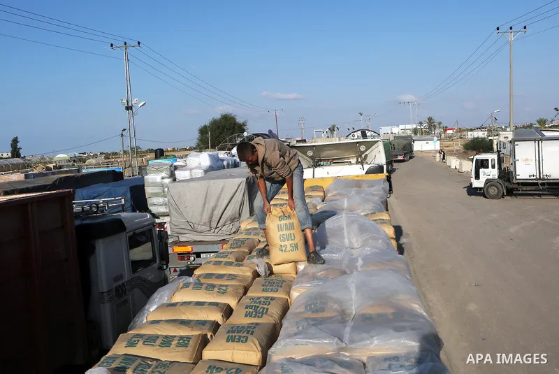A Palestinian worker adjusts bags of cement loaded on a truck that entered the Gaza Strip from Israel through the Kerem Shalom crossing in Rafah in the southern Gaza Strip on November 5, 2014. UN peace envoy Robert Serry...