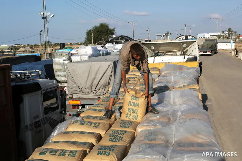 A Palestinian worker adjusts bags of cement loaded on a truck that entered the Gaza Strip from Israel through the Kerem Shalom crossing in Rafah in the southern Gaza Strip on November 5, 2014. UN peace envoy Robert Serry...