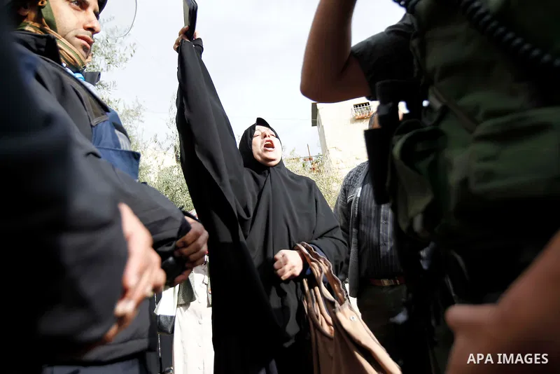 A Palestinian woman shouts as Israeli security forces at one of the entrances to Jerusalem's flashpoint Al-Aqsa mosque during clashes between Israeli police and stone-throwing Palestinians on November 5, 2014. Clashes br...