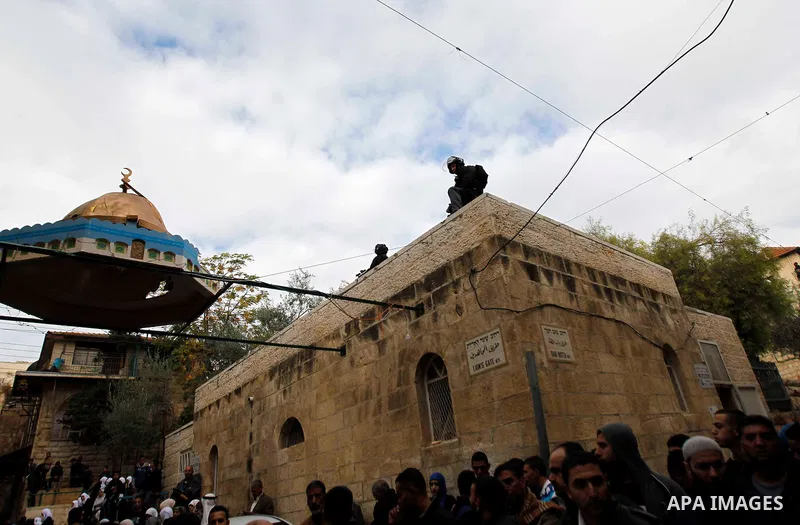 Palestinian protesters shout as Israeli security forces at one of the entrances to Jerusalem's flashpoint Al-Aqsa mosque during clashes between Israeli police and stone-throwing Palestinians on November 5, 2014. Clashes...