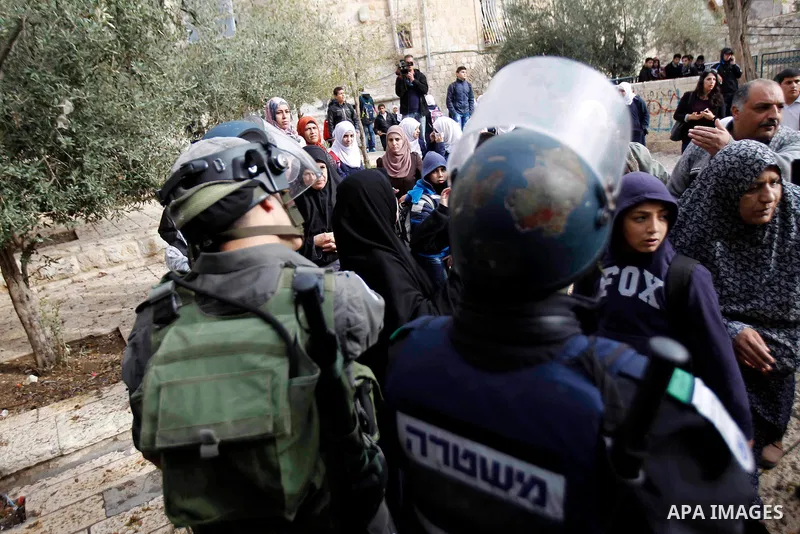 Palestinian protesters shout as Israeli security forces at one of the entrances to Jerusalem's flashpoint Al-Aqsa mosque during clashes between Israeli police and stone-throwing Palestinians on November 5, 2014. Clashes...