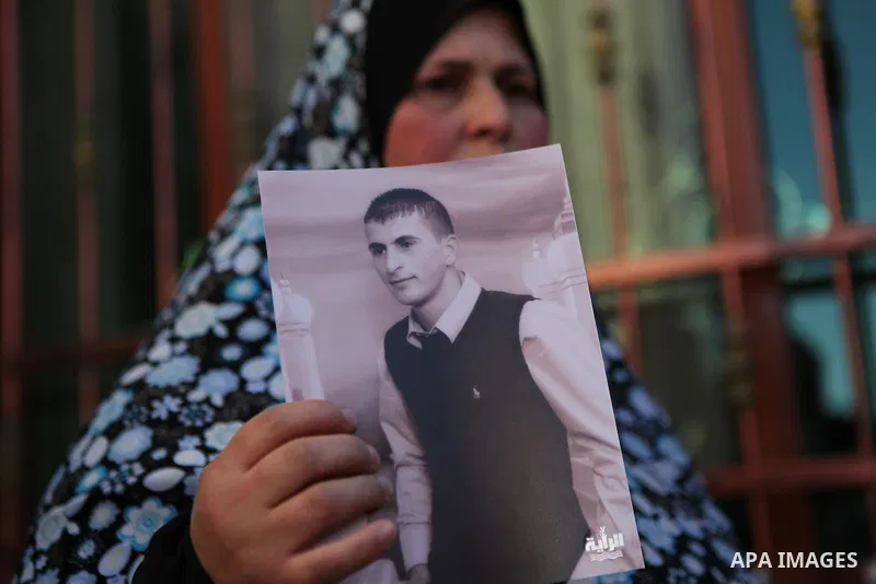Mother of Hammam Hammam Masalma, the suspect in hit-and-run that left three soldiers injured, holds her son's picture, at her house in Beit Awwa, near the West Bank city of Hebron, November 6, 2014. The hit-and-run incid...