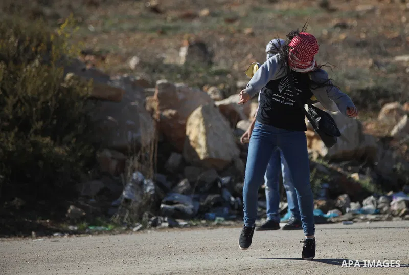 Palestinian students of the Birzeit University throw stones towards Israeli security forces during clashes following an anti-Israel demonstration over the recent entry restrictions to the al-Aqsa mosque, outside Israel's...