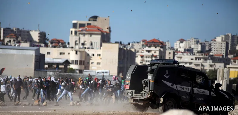 Palestinian students of the Birzeit University throw stones towards Israeli security forces during clashes following an anti-Israel demonstration over the recent entry restrictions to the al-Aqsa mosque, outside Israel's...