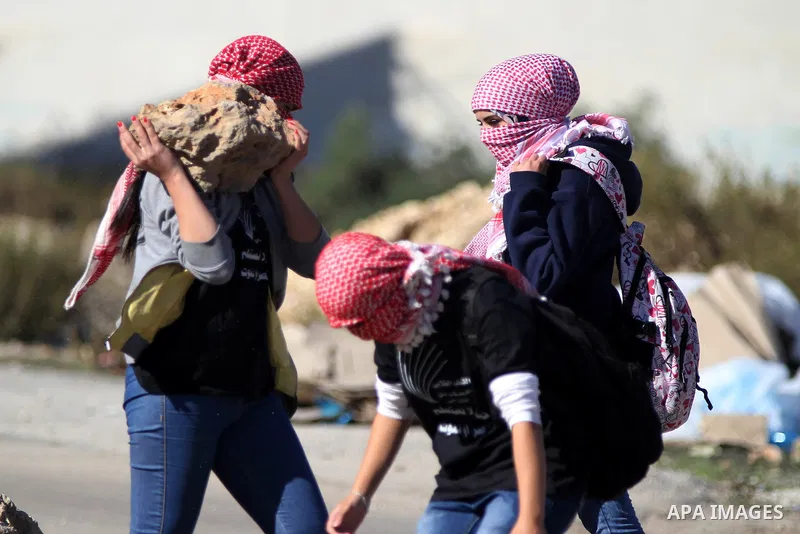 Palestinian girls, who are students of the Birzeit University, hold rocks during clashes with Israeli security forces following an anti-Israel demonstration over the recent entry restrictions to the al-Aqsa mosque, outsi...