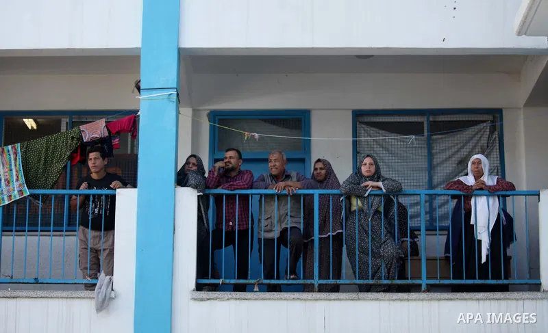 Palestinians, whose houses were destroyed during the most recent conflict between Israel and Hamas, watch European Union foreign policy chief Federica Mogherini (not pictured) as she visits a UN-run school where they are...