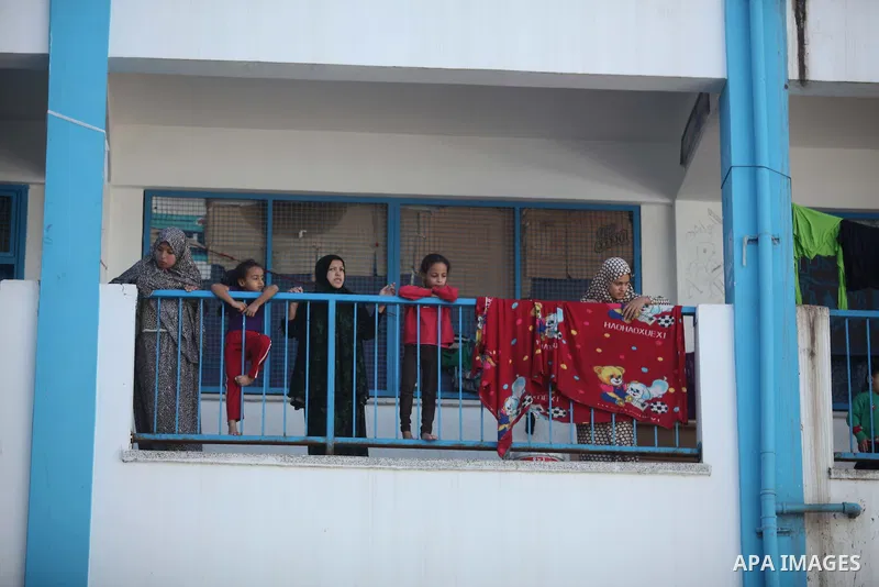Palestinians, whose houses were destroyed during the most recent conflict between Israel and Hamas, watch European Union foreign policy chief Federica Mogherini (not pictured) as she visits a UN-run school where they are...