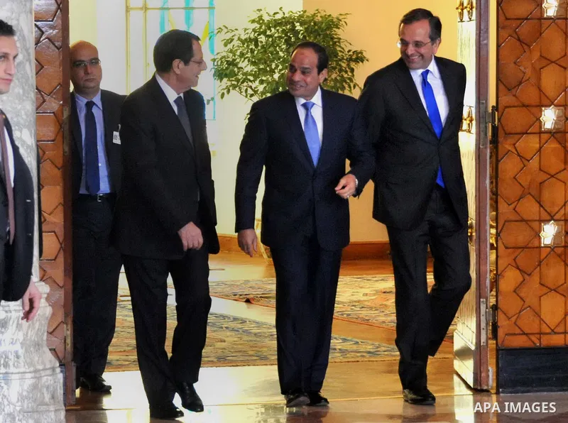 A handout picture released by the Egyptian Presidency shows Egyptian President Abdel-Fattah el-Sissi welcomes Cyprus' President Nicos Anastasiades and Greek Prime Minister Antonis Samaras before a meeting in Cairo on Nov...