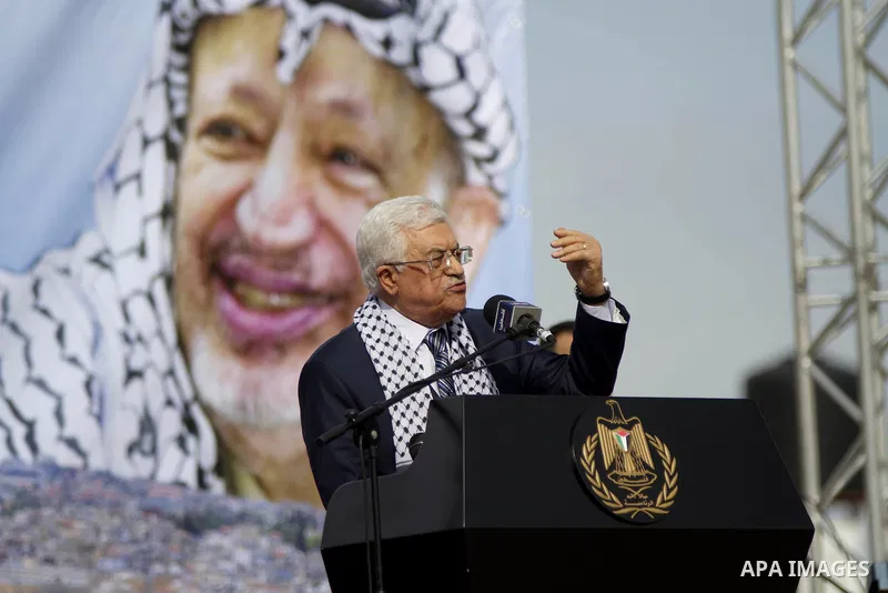 Palestinian president Mahmud Abbas delivers a speech during a ceremony marking 10 years since the death of veteran leader Yasser Arafat (portrait in the background) in the West Bank city of Ramallah on November 11, 2014....