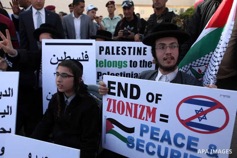 Israeli Ultra-Orthodox Jews who support peace between the Israel and the Palestinian territories hold banners as they attend a rally to mark the tenth anniversary of the death of late Palestinian leader Yasser Arafat in...