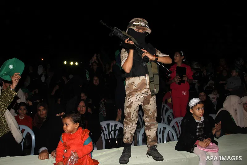 A Palestinian boy holds a gun during an anti-Israel rally in Rafah in the southern Gaza Strip on November 13, 2014. The rally was organized in memory of Hamas's military commanders who were killed during the seven-week I...