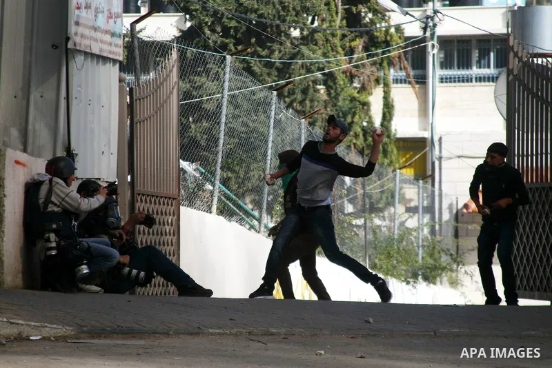 Palestinian protesters throw stones towards Israeli security forces during clashes following a protest against Israel's restrictions at the Al-Aqsa Mosque in Jerusalem, in the West Bank city of Hebron, November 14, 2014....