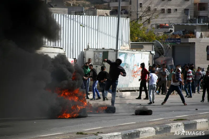 Palestinian protesters throw stones towards Israeli security forces during clashes following a protest against Israel's restrictions at the Al-Aqsa Mosque in Jerusalem, in the West Bank city of Hebron, November 14, 2014....