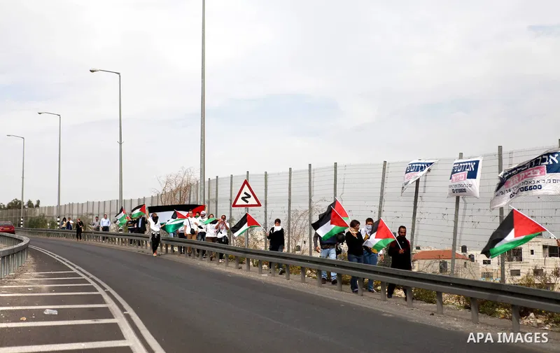Palestinian protesters hold their national flags during a demonstration against Israel's restrictions at the Al-Aqsa Mosque in Jerusalem, in Hizma village near the West Bank city of Ramallah, November 14, 2014. Israel ea...
