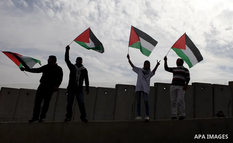 Palestinian protesters hold their national flags during a demonstration against Israel's restrictions at the Al-Aqsa Mosque in Jerusalem, in Hizma village near the West Bank city of Ramallah, November 14, 2014. Israel ea...
