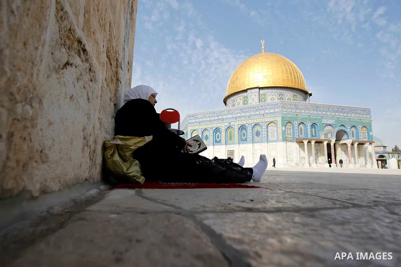 A Palestinian woman prays outside the Dome of the Rock at the Al-Aqsa mosque compound during Friday prayers in the Old City of Jerusalem on November 14, 2014. Israel eased restrictions at Jerusalem's Al-Aqsa mosque after...