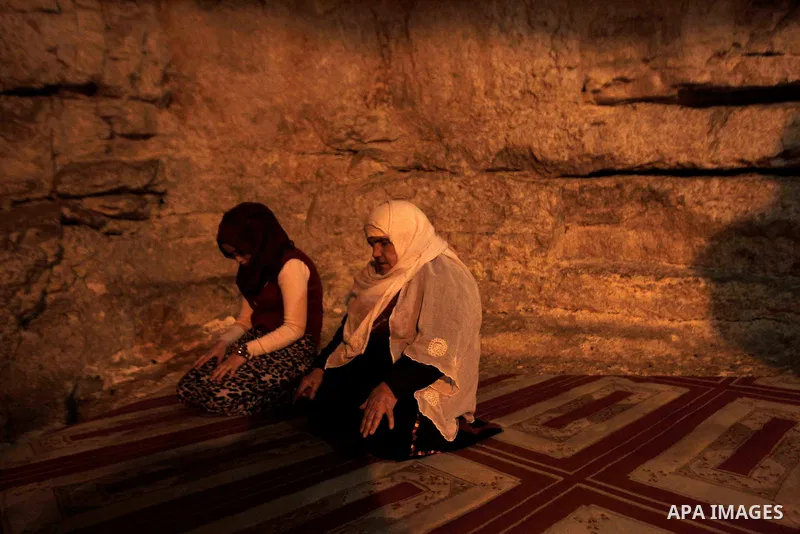 Palestinian women pray under the holy rock at Islam's the Dome of the Rock in the Al-Aqsa mosque compound during Friday prayers in the Old City of Jerusalem on November 14, 2014. Israel eased restrictions at Jerusalem's...
