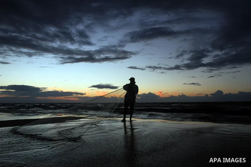 A Palestinian fisherman throws his net into the sea at the beach of Gaza City on Nov. 16, 2014. Photo by Yasser Qudih