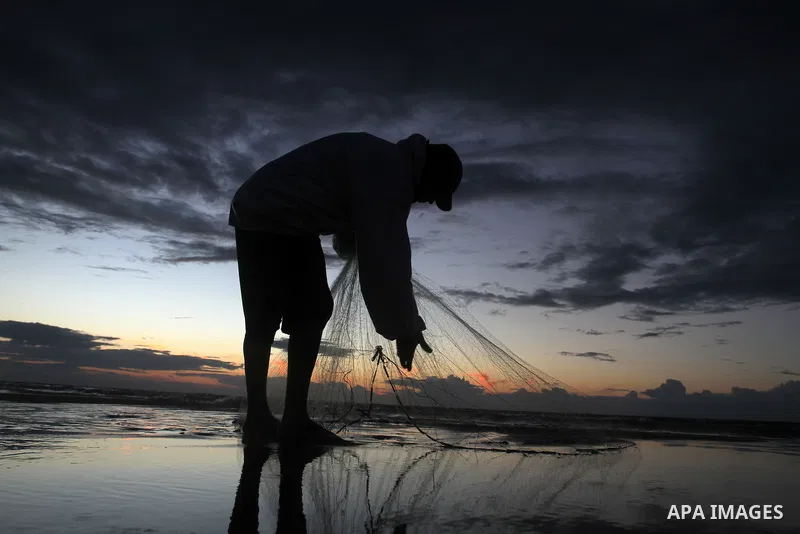 A Palestinian fisherman throws his net into the sea at the beach of Gaza City on Nov. 16, 2014. Photo by Yasser Qudih
