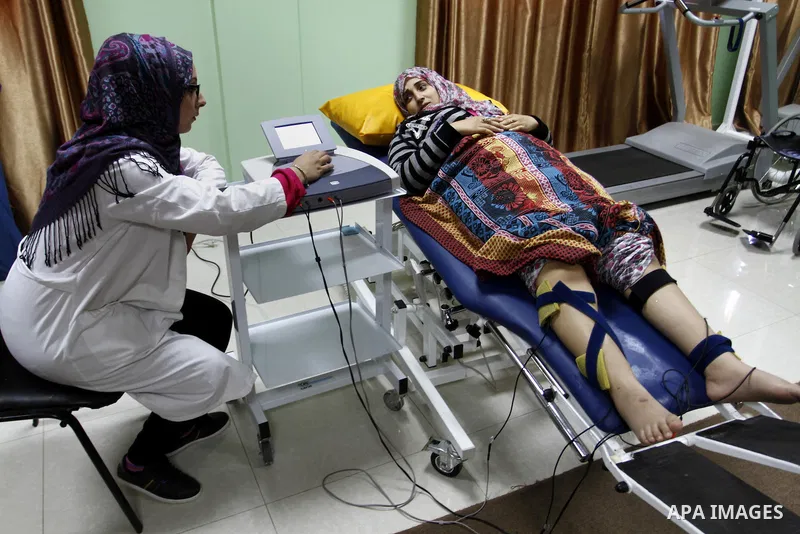 Nedaa Abu Daqqa, 20, a wounded Palestinian girl receives therapy treatment, at a hospital in Khan Younis, in the southern Gaza Strip, November 17, 2014. Abu Daqqa suffers from hemiplegia after she was injured in spine du...