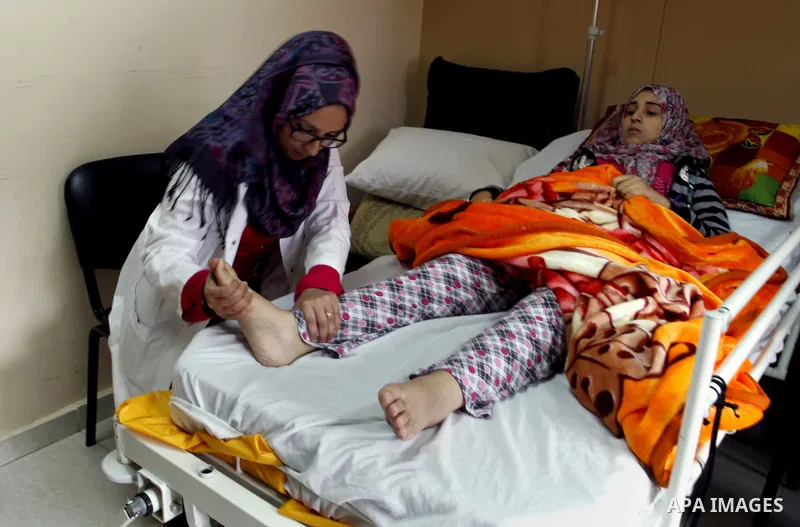 Nedaa Abu Daqqa, 20, a wounded Palestinian girl receives therapy treatment, at a hospital in Khan Younis, in the southern Gaza Strip, November 17, 2014. Abu Daqqa suffers from hemiplegia after she was injured in spine du...