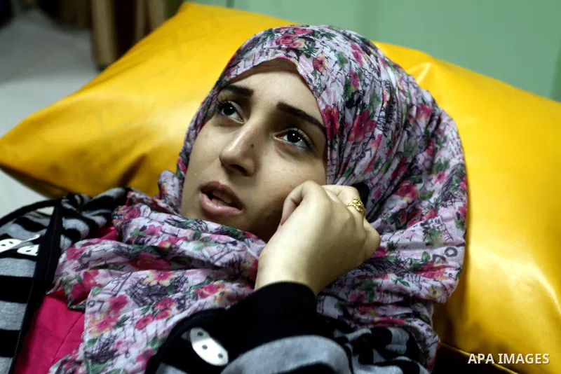 Nedaa Abu Daqqa, 20, a wounded Palestinian girl speaks to phone as she receive therapy treatment, at a hospital in Khan Younis, in the southern Gaza Strip, November 17, 2014. Abu Daqqa suffers from hemiplegia after she w...