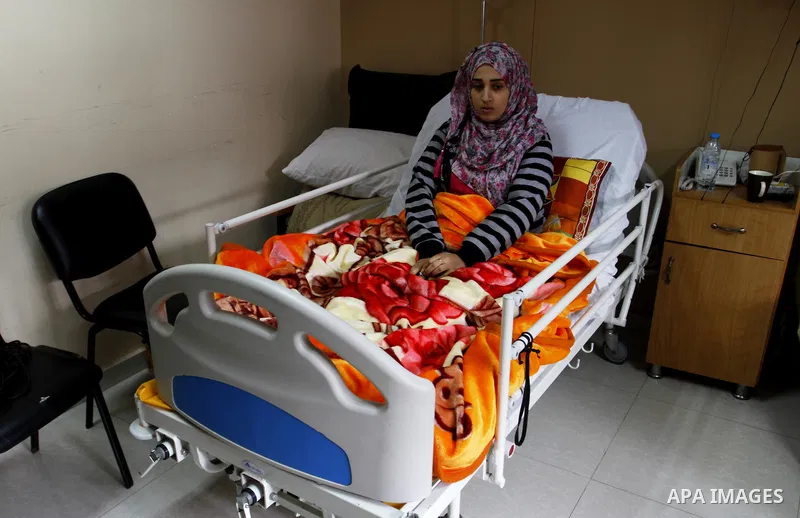 Nedaa Abu Daqqa, 20, a wounded Palestinian girl lays at a hospital bed as she wait to receive therapy treatment, at a hospital in Khan Younis, in the southern Gaza Strip, November 17, 2014. Abu Daqqa suffers from hemiple...