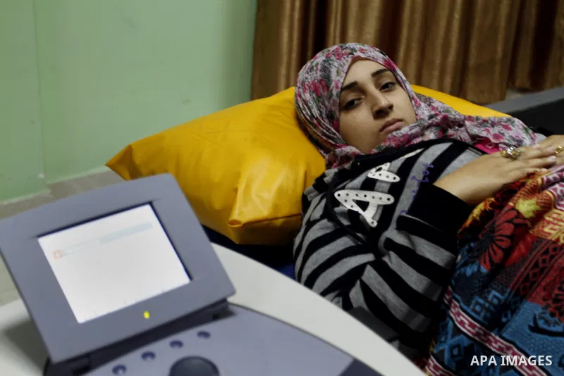 Nedaa Abu Daqqa, 20, a wounded Palestinian girl receives therapy treatment, at a hospital in Khan Younis, in the southern Gaza Strip, November 17, 2014. Abu Daqqa suffers from hemiplegia after she was injured in spine du...