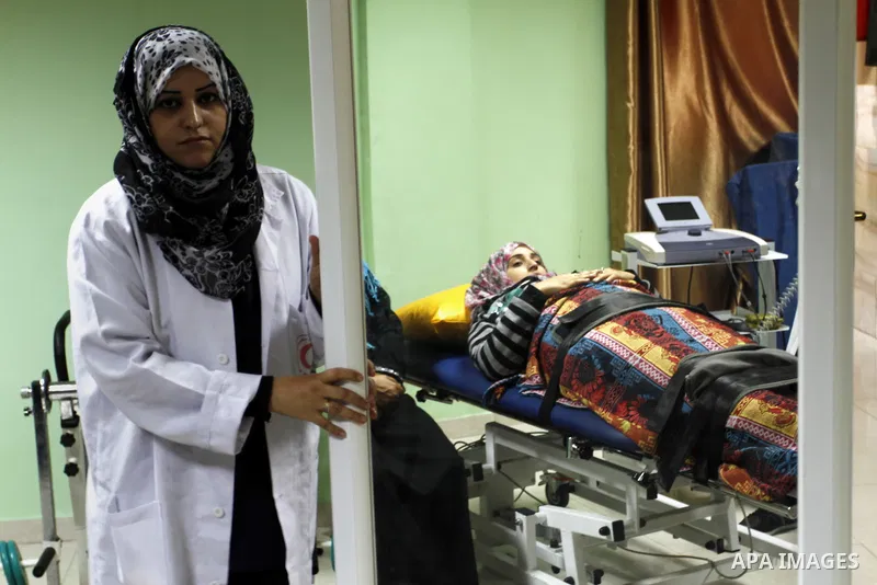 Nedaa Abu Daqqa, 20, a wounded Palestinian girl receives therapy treatment, at a hospital in Khan Younis, in the southern Gaza Strip, November 17, 2014. Abu Daqqa suffers from hemiplegia after she was injured in spine du...