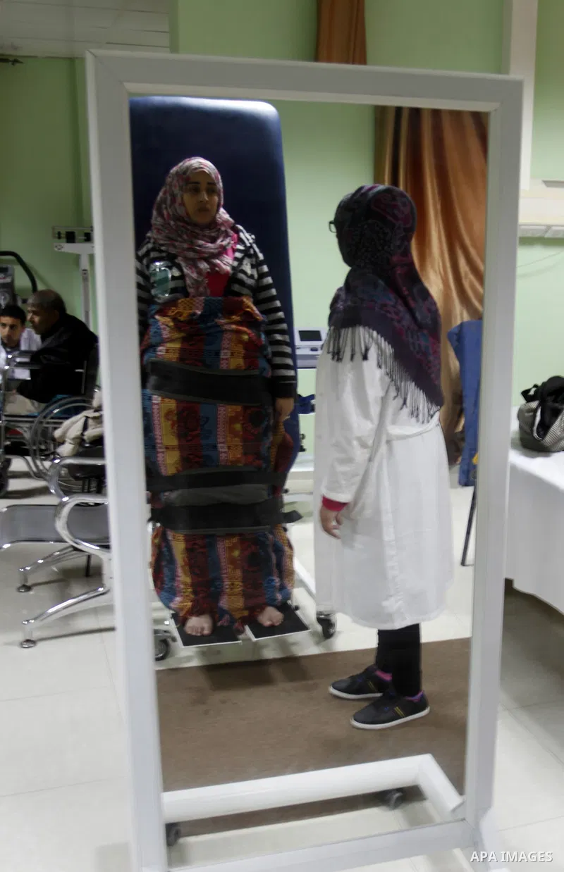 Nedaa Abu Daqqa, 20, a wounded Palestinian girl receives therapy treatment, at a hospital in Khan Younis, in the southern Gaza Strip, November 17, 2014. Abu Daqqa suffers from hemiplegia after she was injured in spine du...