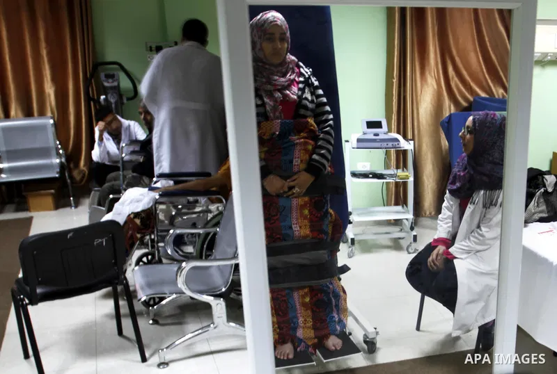 Nedaa Abu Daqqa, 20, a wounded Palestinian girl receives therapy treatment, at a hospital in Khan Younis, in the southern Gaza Strip, November 17, 2014. Abu Daqqa suffers from hemiplegia after she was injured in spine du...