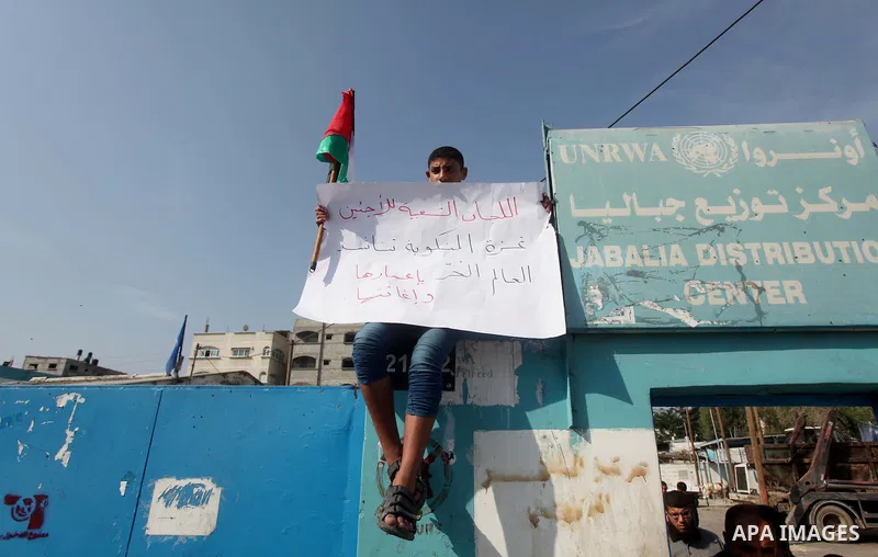 Palestinians hold banners during a protest to demand for reconstruction of the houses which were destroyed by Israeli shelling during the most recent conflict between Israel and Hamas, in front of the Supply Center for U...