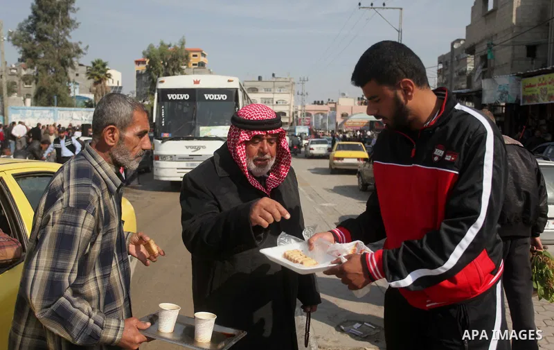 A Palestinian man distributes sweets as he celebrates with others an attack on a Jerusalem synagogue, in Gaza city November 18, 2014. Two Palestinians armed with a meat cleaver and a gun killed four people in a Jerusalem...