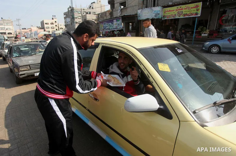 A Palestinian man distributes sweets as he celebrates with others an attack on a Jerusalem synagogue, in Gaza city November 18, 2014. Two Palestinians armed with a meat cleaver and a gun killed four people in a Jerusalem...