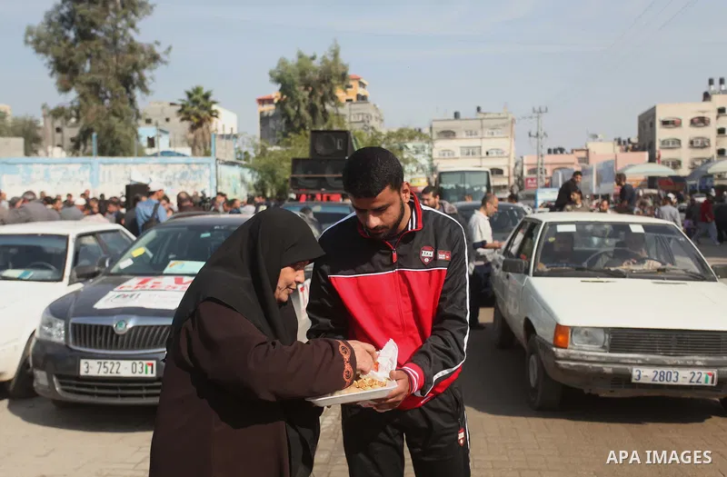 A Palestinian man distributes sweets as he celebrates with others an attack on a Jerusalem synagogue, in Gaza city November 18, 2014. Two Palestinians armed with a meat cleaver and a gun killed four people in a Jerusalem...