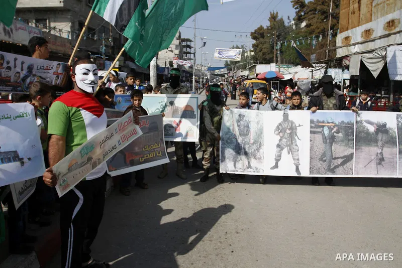 Palestinians celebrate with others an attack on a Jerusalem synagogue, in Rafah in the southern Gaza Strip November 18, 2014. Two Palestinians armed with a meat cleaver and a gun killed four people in a Jerusalem synagog...