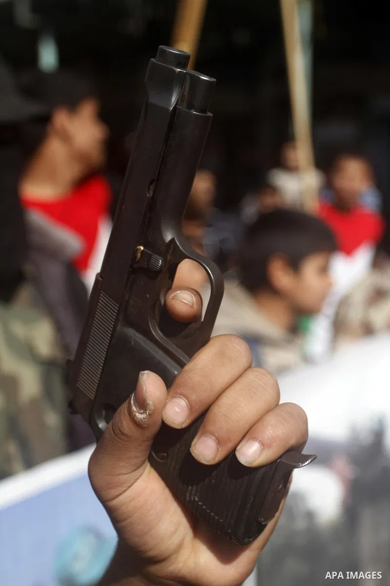 A Masked Palestinian holds a gun as he celebrates with others an attack on a Jerusalem synagogue, in Rafah in the southern Gaza Strip November 18, 2014. Two Palestinians armed with a meat cleaver and a gun killed four pe...