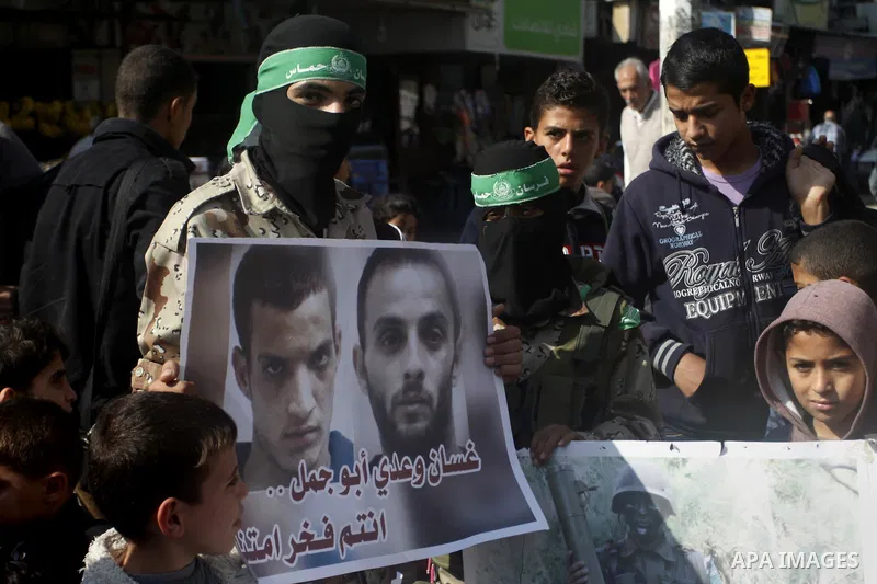Palestinians celebrate with others an attack on a Jerusalem synagogue, in Rafah in the southern Gaza Strip November 18, 2014. Two Palestinians armed with a meat cleaver and a gun killed four people in a Jerusalem synagog...