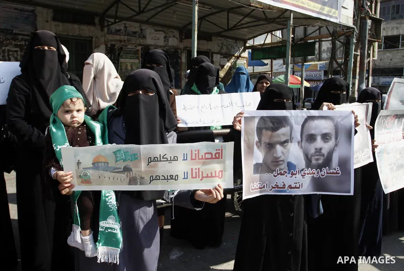 Palestinians celebrate with others an attack on a Jerusalem synagogue, in Rafah in the southern Gaza Strip November 18, 2014. Two Palestinians armed with a meat cleaver and a gun killed four people in a Jerusalem synagog...