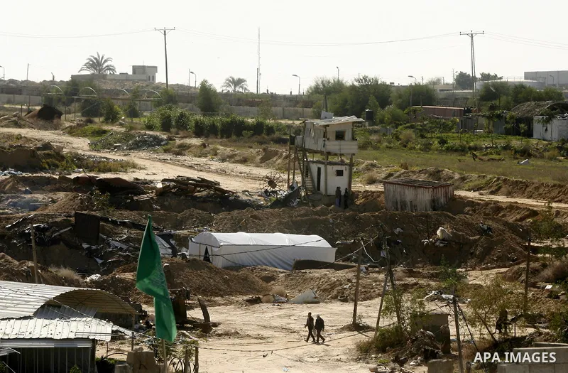 Palestinians walk near smuggling tunnels during a military operation by Egyptian security forces in the Egyptian city of Rafah near the border with southern Gaza Strip on November 20, 2014. Egypt is set to expand the buf...