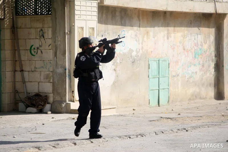 A member of Israeli security forces fires tear gas towards Palestinian protesters during clashes following a protest against the recent Israeli measures in Jerusalem, in the West Bank city of Hebron, November 21, 2014. I...
