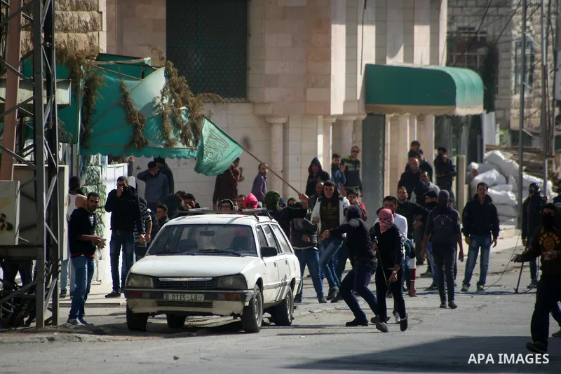 Palestinian protesters throw stones towards Israeli security forces during clashes following a protest against the recent Israeli measures in Jerusalem, in the West Bank city of Hebron, November 21, 2014. Israel eased ag...
