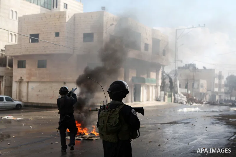 A member of Israeli security forces fires tear gas towards Palestinian protesters during clashes following a protest against the recent Israeli measures in Jerusalem, in the West Bank city of Hebron, November 21, 2014. I...