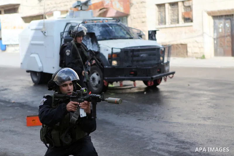 A member of Israeli security forces fires tear gas towards Palestinian protesters during clashes following a protest against the recent Israeli measures in Jerusalem, in the West Bank city of Hebron, November 21, 2014. I...